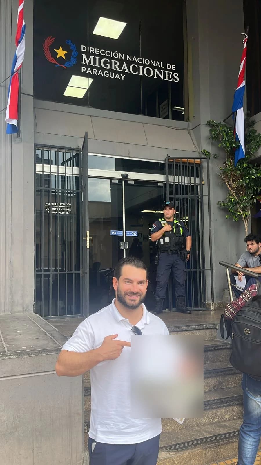 Ernesto apontando para o comprovante do processo, em frente à Dirección Nacional de Migraciones, em Assunção