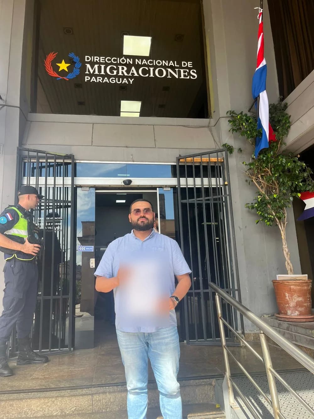 Gilson com o comprovante do processo, em frente à Dirección Nacional de Migraciones, em Assunção