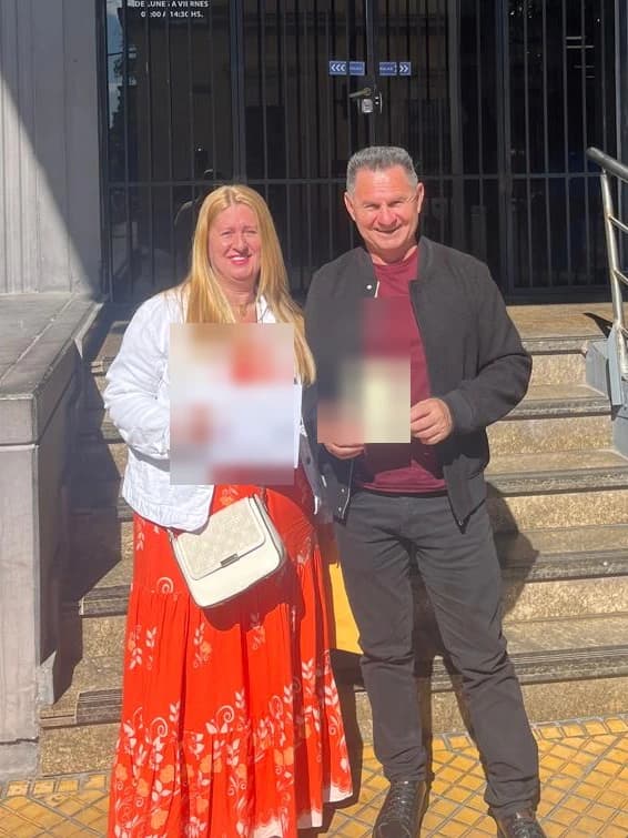Cliente e esposa com o comprovante do processo, em frente à Dirección Nacional de Migraciones, em Assunção