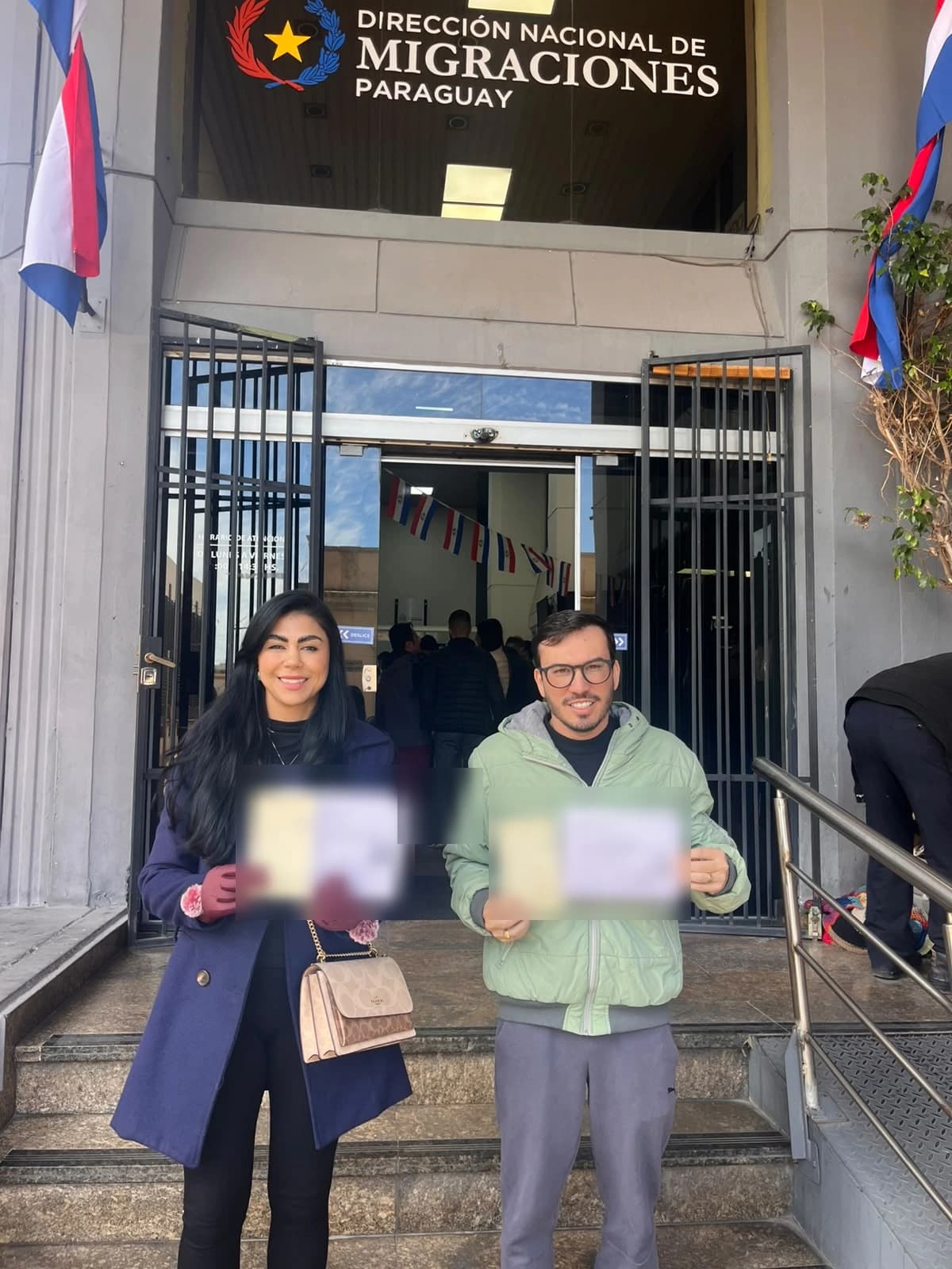 Mariana e Luigi com os comprovantes do processo, em frente à Dirección Nacional de Migraciones, em Assunção
